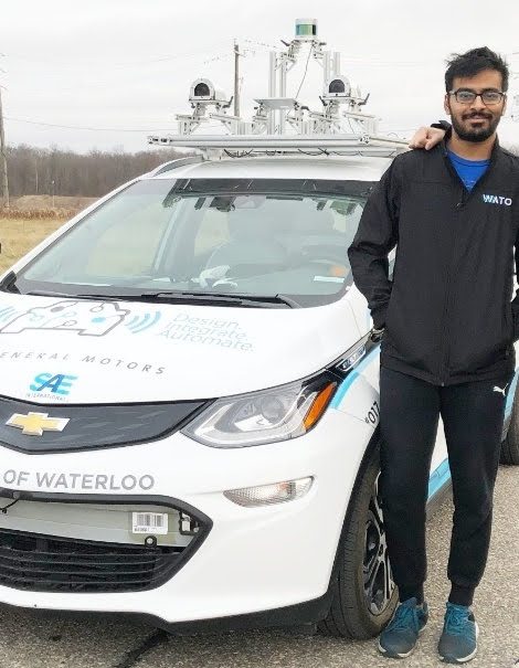Kushant Patel standing beside the WATonomous self-driving car